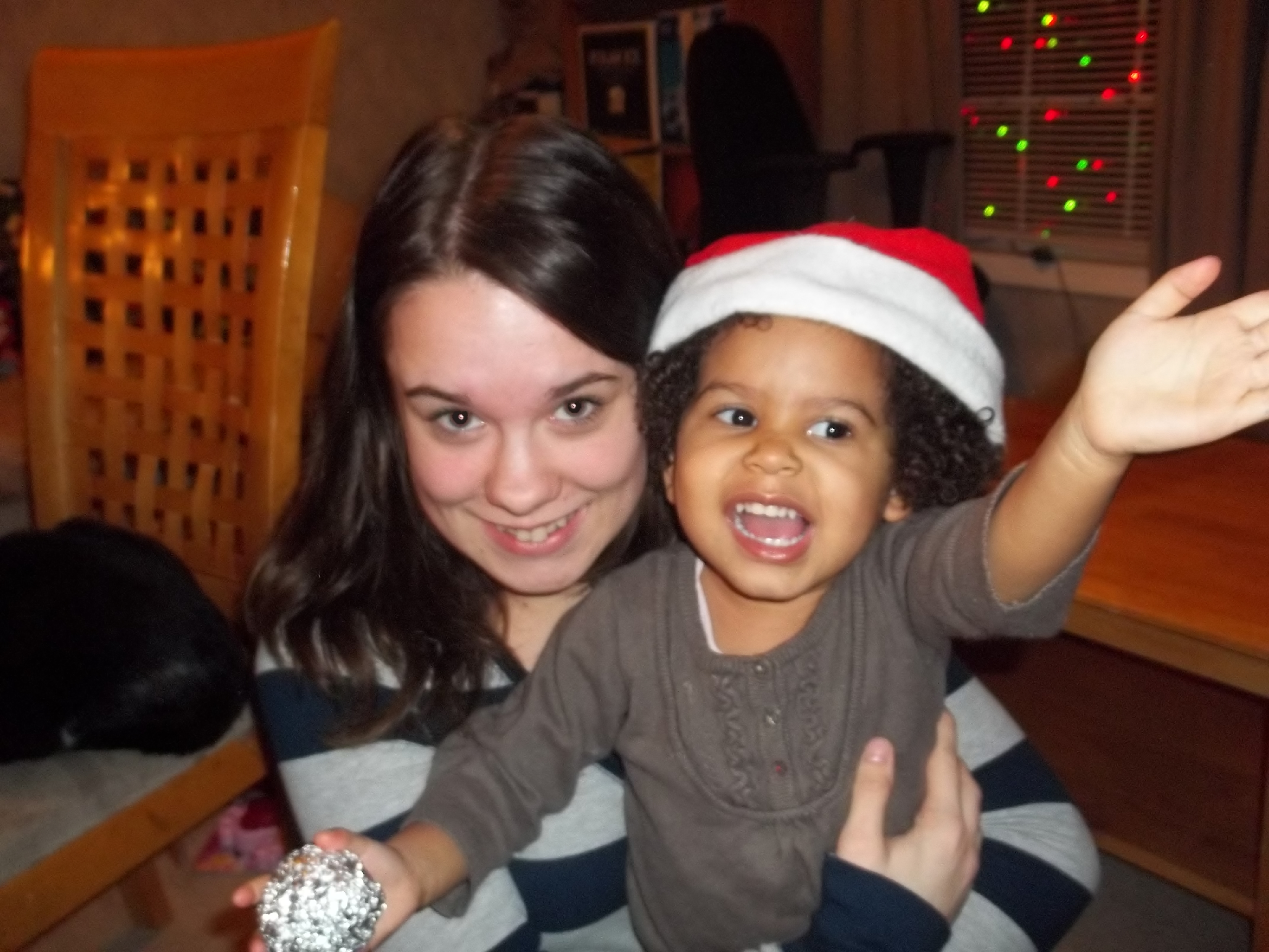 woman and child wearing a santa hat and smiling at the camera