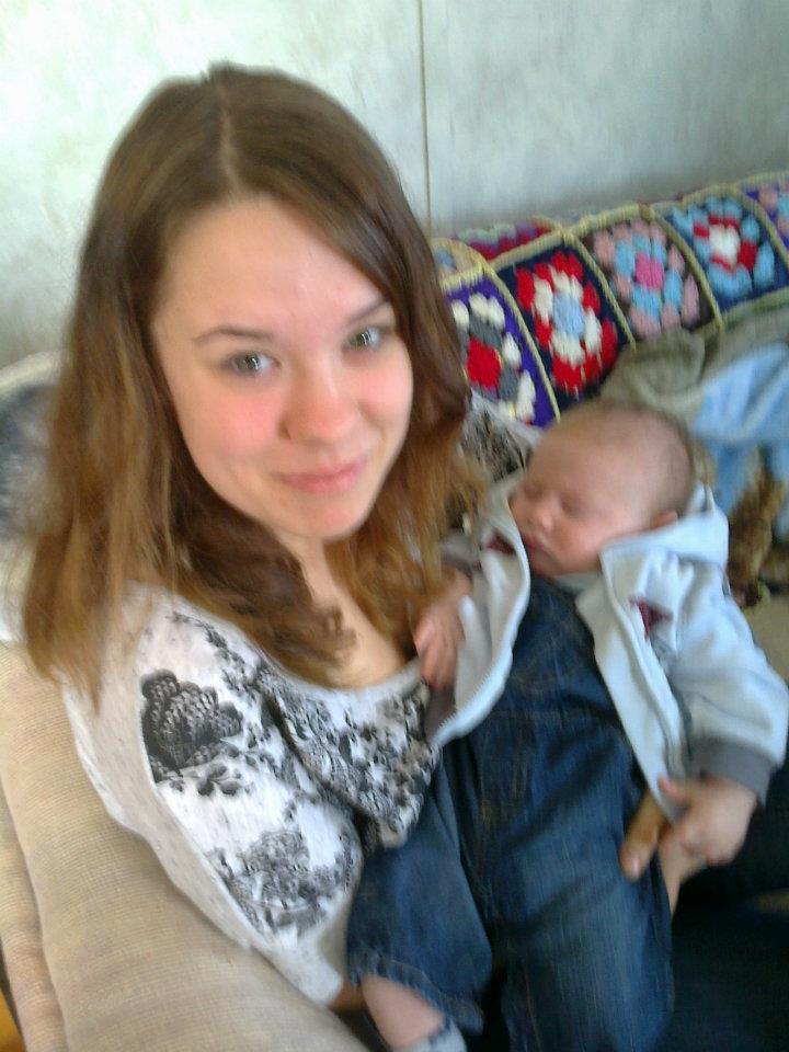 woman holding a newborn baby on the couch