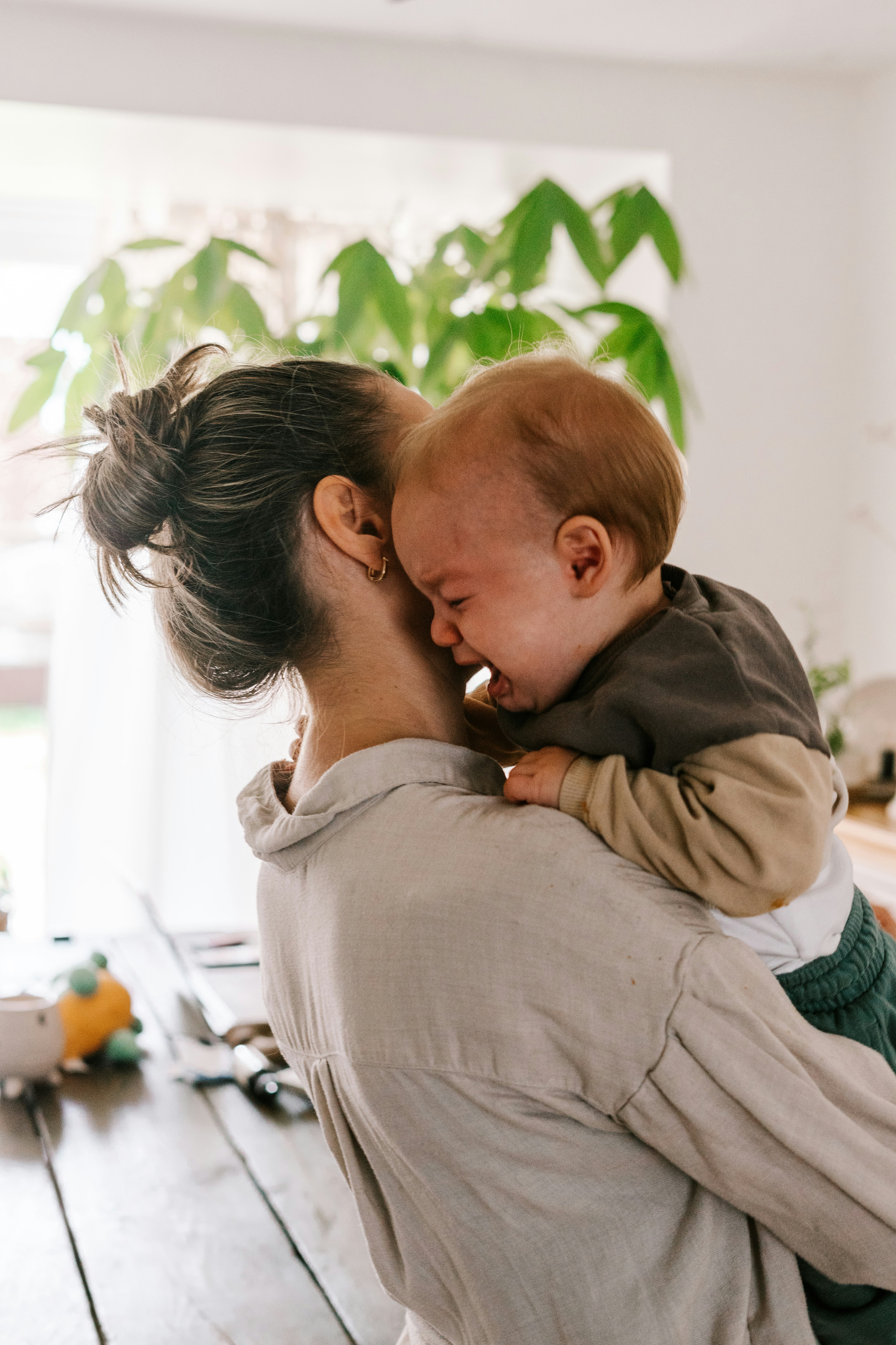 Woman holding a crying baby over her shoulder